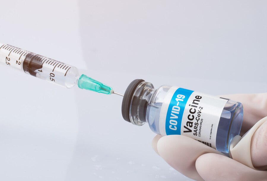 Close up, Hand holding Covid-19 Vaccine bottle and taking the liquid vaccine.