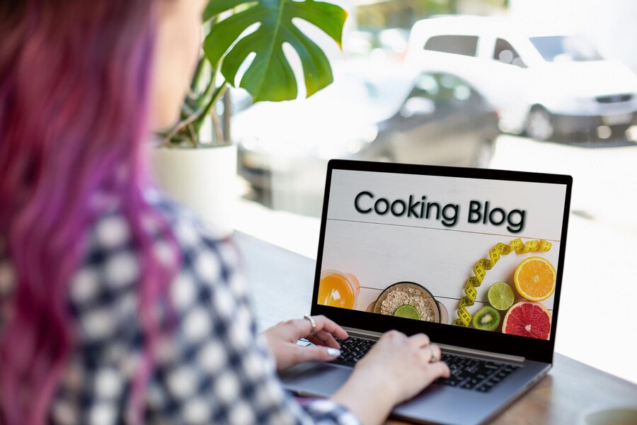 back view of young woman watching blog video about healthy food on laptop